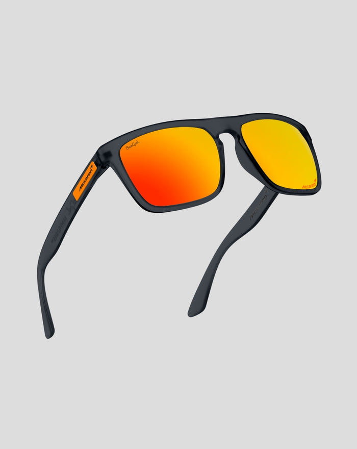 Angled view of SunGod Core Renegades sunglasses with a dark frame and orange mirrored lenses McLaren branding on the temple