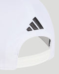 White cap close-up showing a black Adidas logo near the adjustable back strap