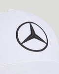 White cap close-up of the front with a black Mercedes emblem embroidered in a circle