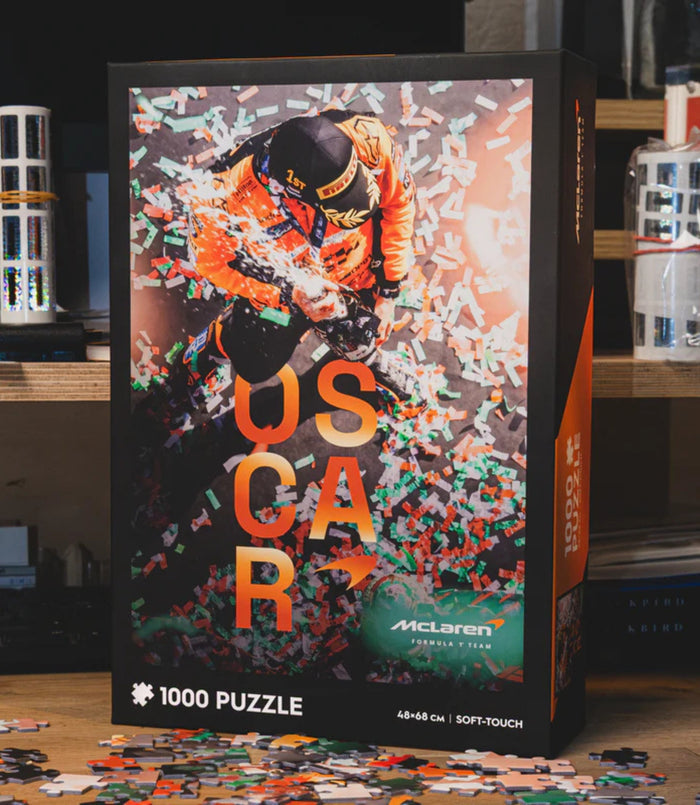 McLaren Formula 1 Oscar Piastri 1000 piece puzzle box art showing a driver in an orange suit amid confetti