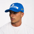 Blue Nacional replica cap worn by model showing white Nacional logo on crown and Senna signature on the side