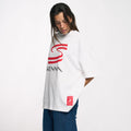 Three quarter view of a model in a white oversized Ayrton Senna graphic T shirt with a large red S logo and SENNA text.