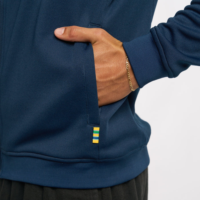 Detail of navy jacket hem showing multicolor stripe tab