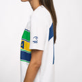 Side view of a model in a white Ayrton Senna T shirt featuring a large blue number graphic on the back.