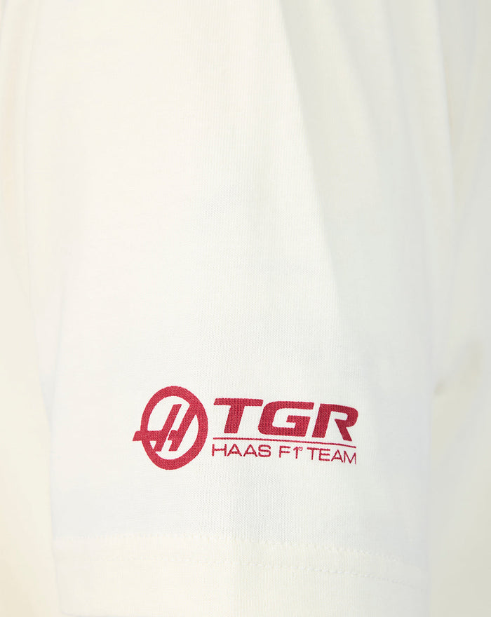Close-up of an Egret white T-shirt sleeve showing the Haas F1 Team TGR logo in red