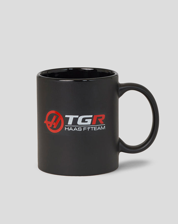 Official Haas F1 Team mug in black with red and white logos and a sturdy handle.