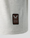 Close up of a brown Castore patch with Oracle Red Bull Racing branding on light gray fabric.