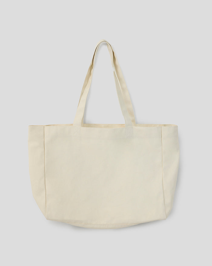 Cream canvas tote bag shown from the front with long straps and a plain minimalist design