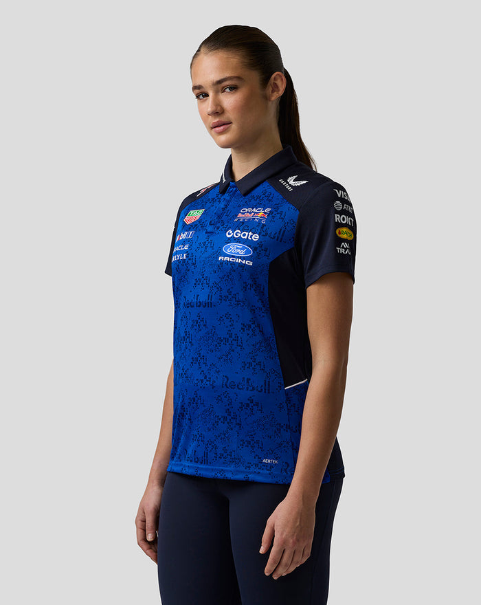 Female model wearing blue Oracle Red Bull Racing Teamline polo with sponsor logos and AerTek branding