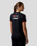 Back view of a woman wearing a black Official Haas Team Women's Driver T Shirt with large back logos and a small USA flag.