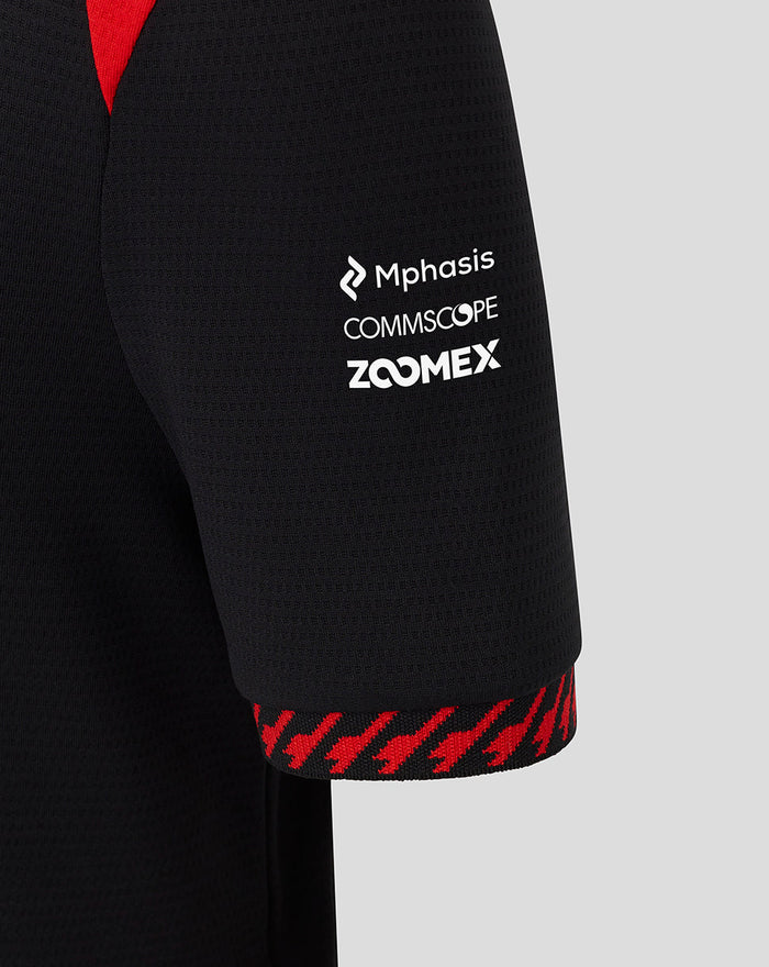 Sleeve close up showing sponsor logos Mphasis Commscope and Zoomex with a red patterned cuff on the Haas polo.