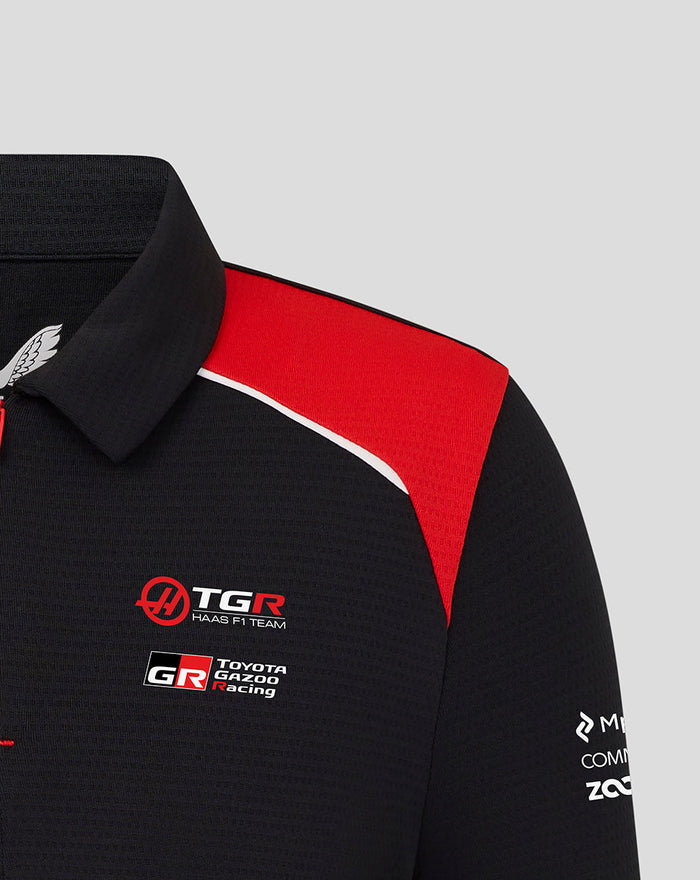 Collar and shoulder close up of black Haas polo with red panel and Haas and Toyota Gazoo Racing logos on the chest