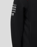 Shoulder close-up of black Haas Team hoodie with red patch bearing Castore branding and white wing logo