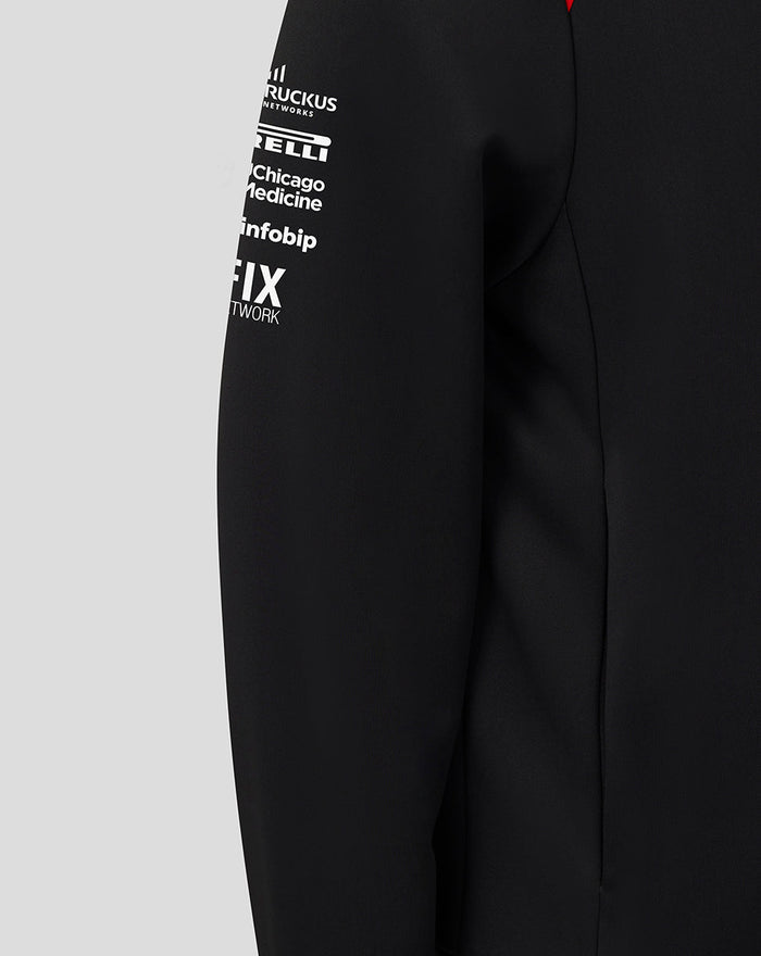 Shoulder close-up of black Haas Team hoodie with red patch bearing Castore branding and white wing logo