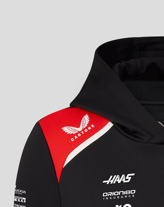 Shoulder and chest area of black Haas Team hoodie featuring red patch with Castore logo and multiple sponsor logos