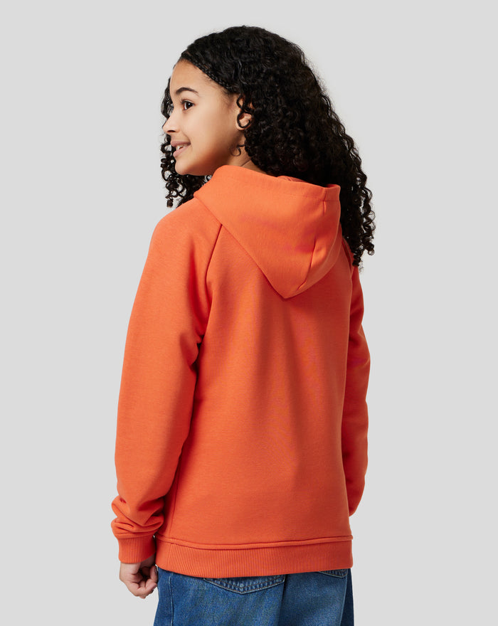 Profile of a child in orange rust hoodie with hood down and chest logo visible