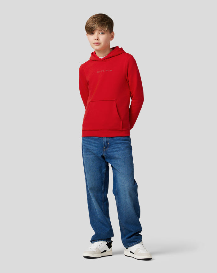 Boy in Junior Silverstone Core Hoodie Racing Red with a red fleece hoodie and front kangaroo pocket