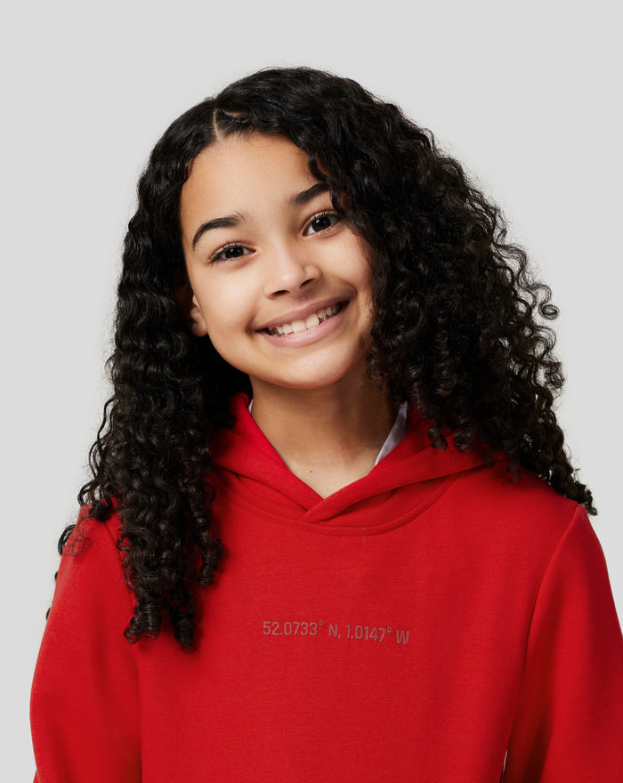 Side profile of a child wearing a red hoodie with large vertical print down the back.