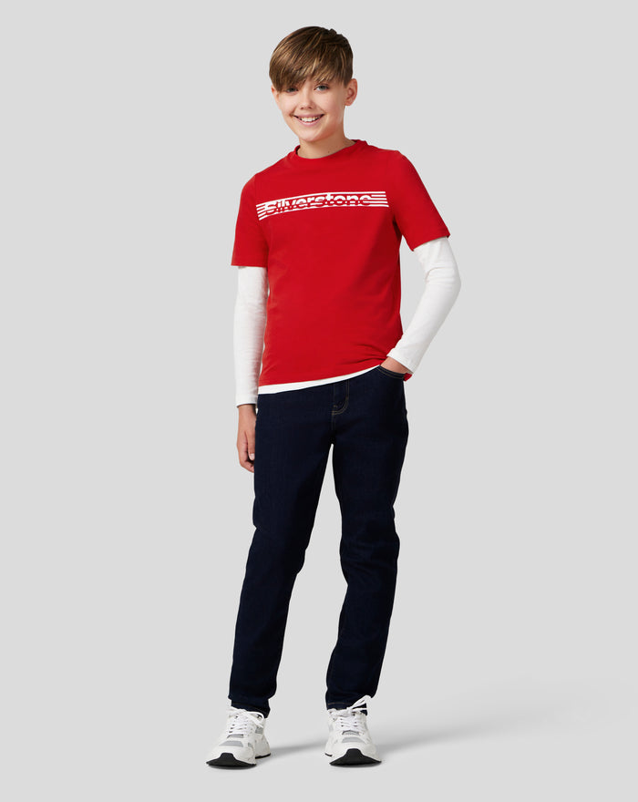 Smiling boy in a red Silverstone Core T Shirt with a white long sleeve underneath and a striped chest logo.