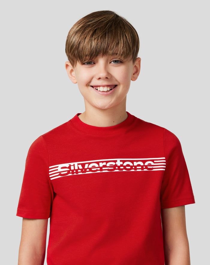 Front view of smiling junior wearing Racing Red Silverstone Core T-Shirt with chest graphic and back neck silicone print
