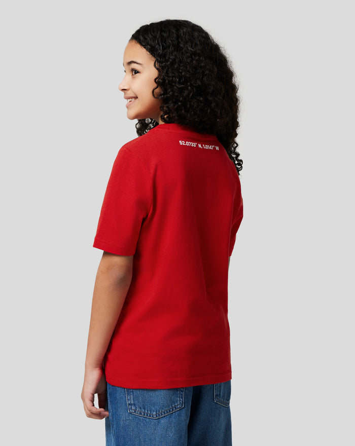 Side view of a child wearing a red Junior Silverstone Core T Shirt with coordinates printed on the back.