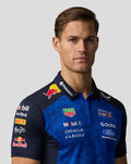 Close-up front view of a man wearing a blue Red Bull Racing polo showing the chest panel collar and sponsor logos.