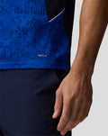 Close up of blue patterned fabric and side pocket on Oracle Red Bull Racing polo with AerTek branding at the hem