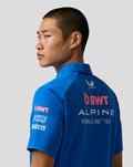 Back view of the blue BWT Alpine polo featuring large team logo across the back and sponsor patches on the sleeve.