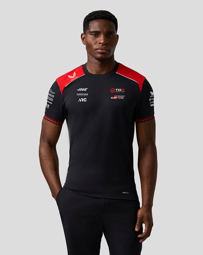 Front view of a model wearing the Official Haas Team Driver T Shirt in black with red shoulder panels and chest logos.