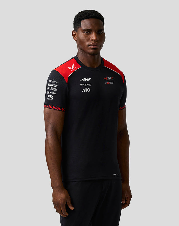 Male model in Official Haas Team Men's Driver T Shirt black with red shoulder panels and white piping along the chest