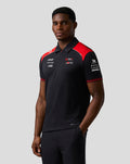 Side view of a male model in a black Haas Team Short Sleeve Polo Shirt with red shoulder panels and back branding.