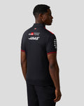 Back view of a male model in a black Haas Team Short Sleeve Polo Shirt with red accents and sponsor logos.
