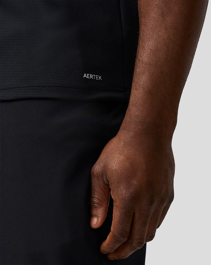 Close-up of black Official Haas Team polo showing AERTEK fabric at the front lower hem