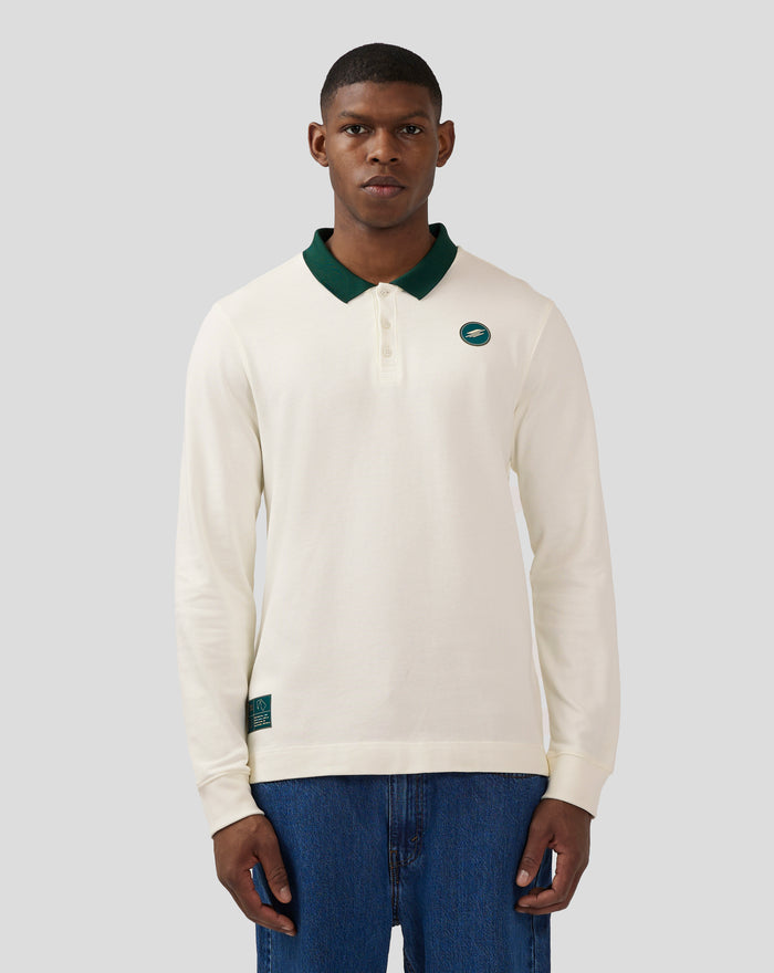 Close up of a male model wearing Coconut Milk heritage polo with dark green collar and chest logo.