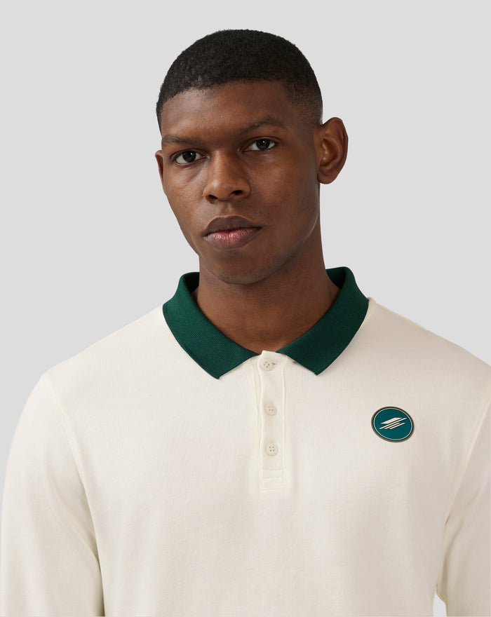 Model in coconut milk polo with green collar; logo badge on chest and care tag visible at the hem.