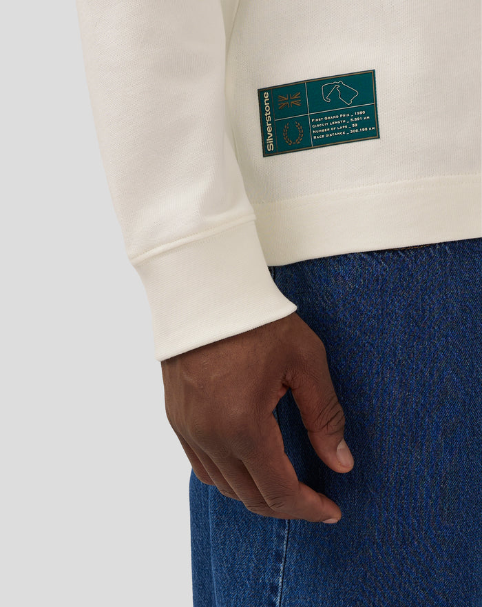 Coconut milk colored long sleeve polo sleeve with teal Silverstone heritage patch on the cuff