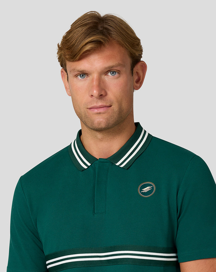 Model wearing a green Silverstone x Castore Heritage Polo with white striped collar and chest logo.