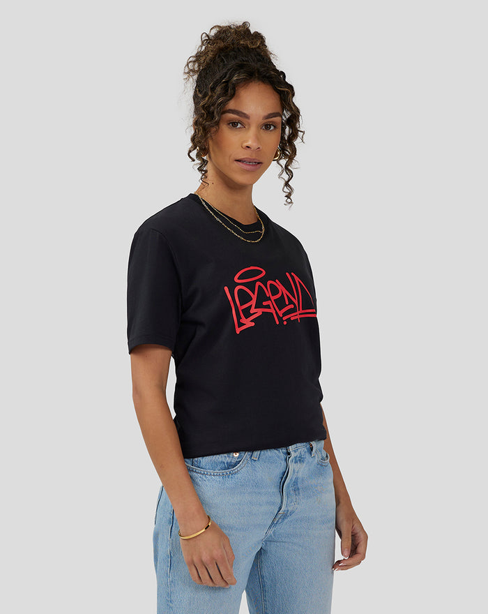 Side view of a woman wearing a black Unisex Silverstone Legend T-Shirt with a red graffiti logo.