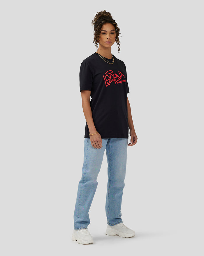 Unisex Silverstone Legend T-Shirt in anthracite with red graphic worn by a model in light wash jeans and white sneakers.