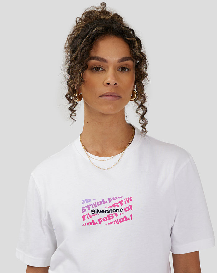 Close up of a woman wearing the white Silverstone x Castore Festival Graphic T-Shirt showing a small colorful chest graphic