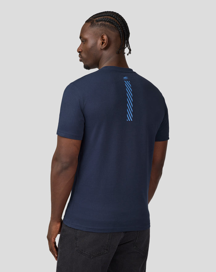 Back view of a man wearing a navy Core Track Graphic T-Shirt with a blue vertical stripe down the back.