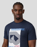 Front view of a man wearing a navy Core Track Graphic T-Shirt with a large white graphic and blue stripes on the chest.
