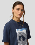 Close up of a woman wearing a navy Silverstone Core Track Graphic T Shirt with a bold white graphic and blue diagonal accents.