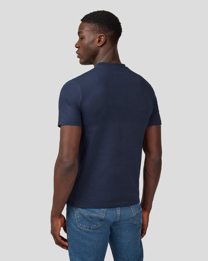 Back view of a man wearing a navy Silvertone Core T Shirt with blue jeans