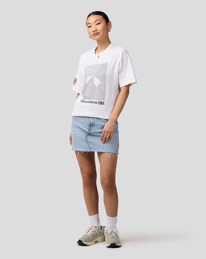 Model wearing white Silverstone Core T Shirt with a geometric front print and Union Jack sleeve patch, paired with a light denim skirt