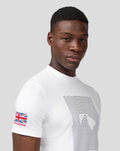Portrait of a man wearing a white Silverstone Core T-Shirt against a light gray background.