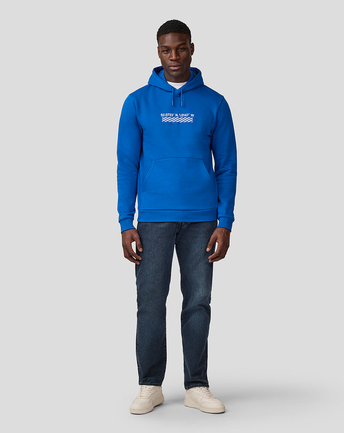 Front view of a man in a blue Silverstone Core Hoodie with white coordinates graphic on the chest
