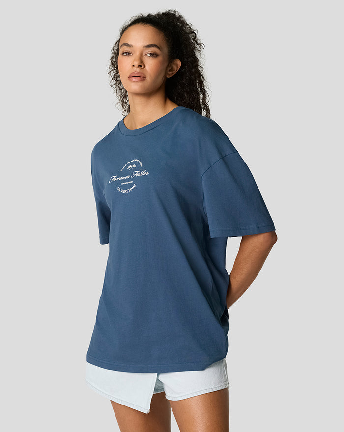 Full body shot of a model in a blue oversized Silverstone T shirt paired with light denim shorts