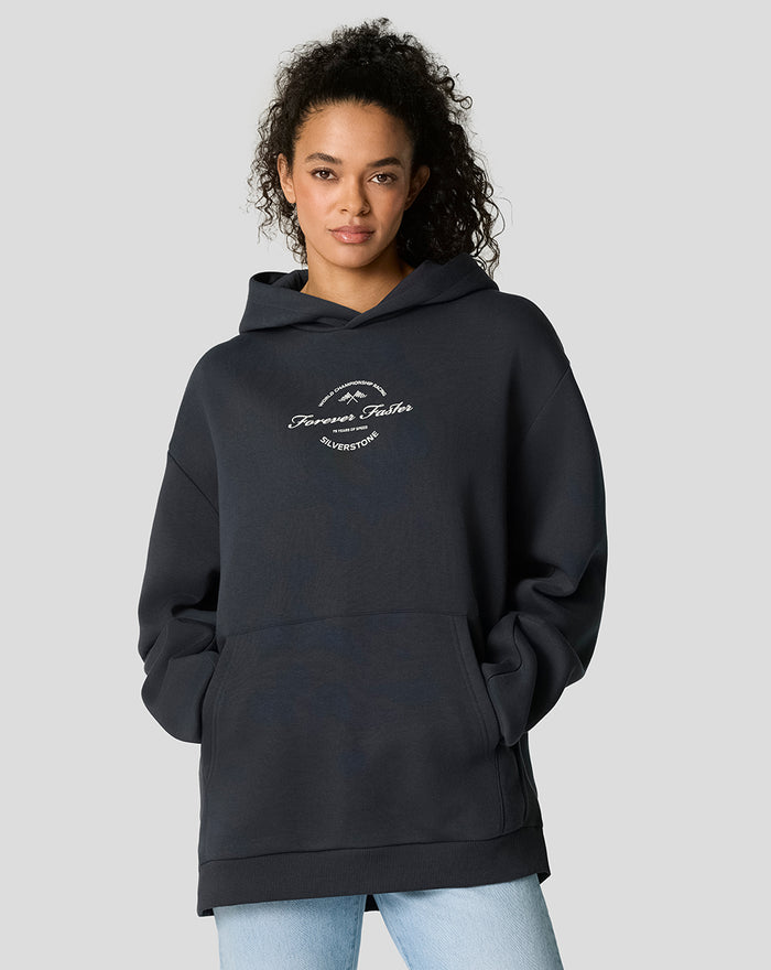 Front view of model wearing dark navy oversized hoodie with a white circular chest emblem