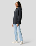 Side profile of model in dark navy oversized hoodie featuring a small white chest logo